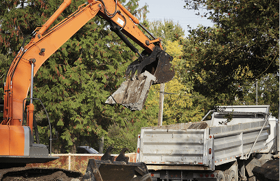 Excavator lifting dirt at a site