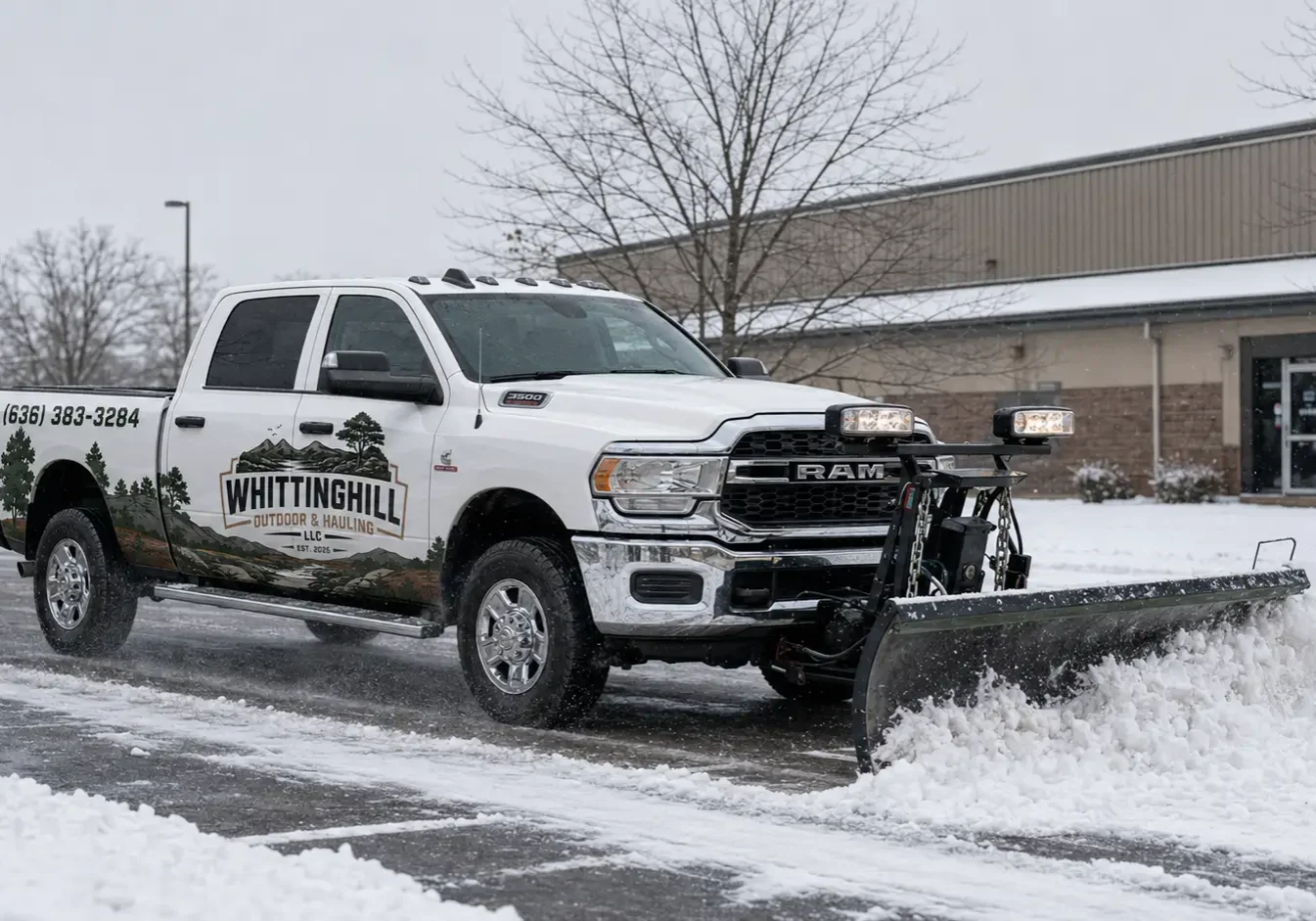 White truck with a snow plow parked in front of a building, surrounded by trees, plants, and a light pole